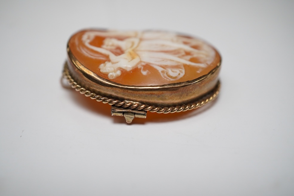 A yellow metal mounted oval cameo shell brooch, carved with The Three Graces, 30mm, gross weight 8 grams. Condition - fair